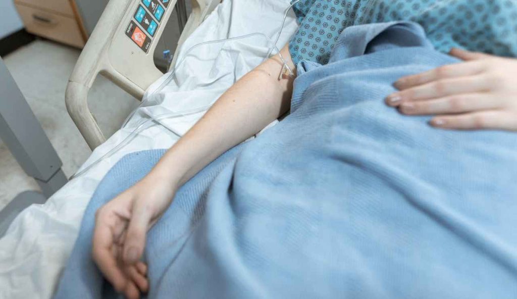 Foto di braccio di persona su letto di ospedale